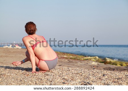 Woman sitting on the beach and watching the sea