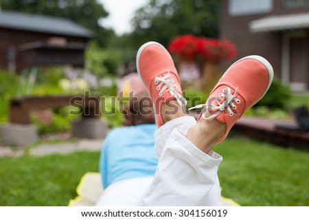 Women\'s feet in the rubber shoes on the garden background