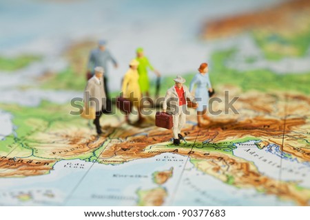 European Tourism And Travel, a group of miniature model tourists with luggage on a map of Europe, shallow DOF