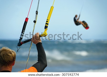 A young man kitesurfer ready for kite surfing rides in blue sea