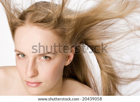 Face shot of gorgeous blonde model with hair blowing in the wind.
