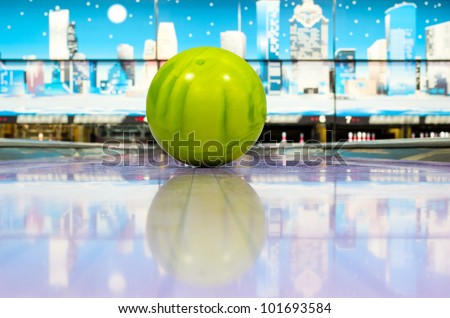 Green sphere ball standing on bowling lane before strike