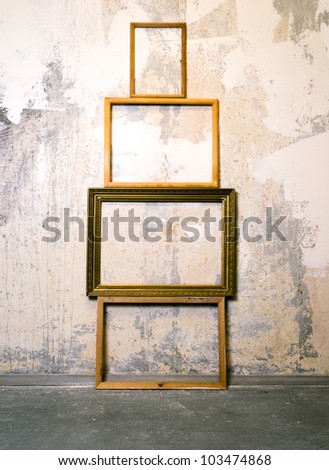 Dirty old room with empty picture frames on the wall. Grunge vintage interior