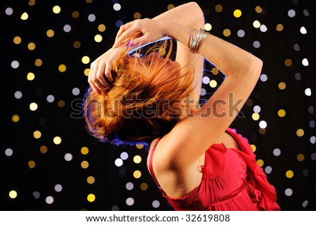 Redhead young woman dancing in the nightclub