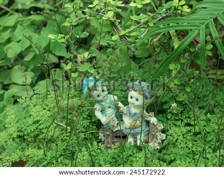 A girl and a boy dolls,sitting on the green grass meadow (love concept)