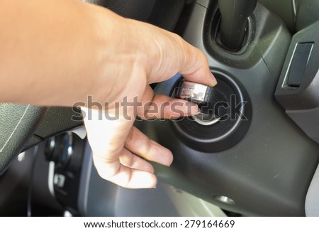 Hand holding car key for starting the car.