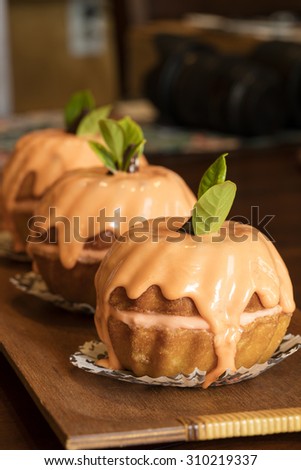 Mini orange bundt cakes for a Halloween party celebration with orange cream glaze and cream cheese frosting