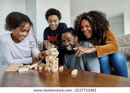 Image, Stock Photo Excited girl playing jenga game with her mom in play room. Girl removing one block from stack and placing it on top of tower. Game of skill and fun. Family time