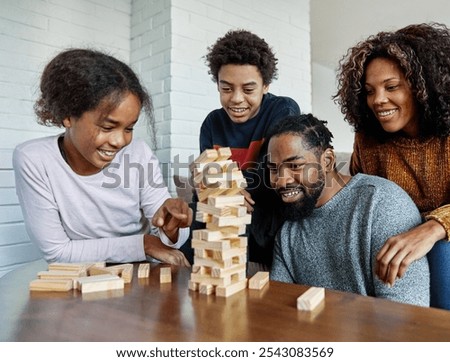 Similar – Image, Stock Photo Excited girl playing jenga game with her mom in play room. Girl removing one block from stack and placing it on top of tower. Game of skill and fun. Family time