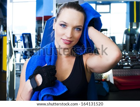 Beautiful girl in the sport club. She is toweling off.