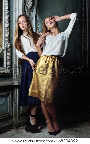 Two beautiful women posing in obsolete interior. Studio with interior of old palace. Not necessary property release.