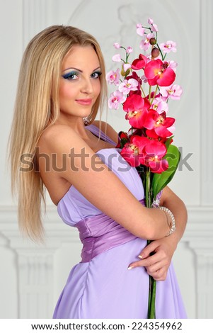 Beautiful woman with orchid, in evening gown. Studio shoot.