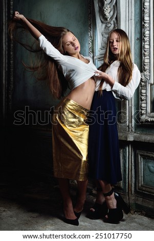 Two beautiful women posing in obsolete interior. Studio with interior of old palace. Not necessary property release.