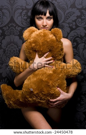 Beautiful naked girl is holding th? teddy bear