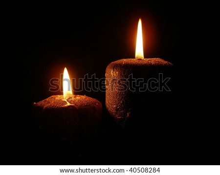 golden burning candles on a black background (look at my candles photo)