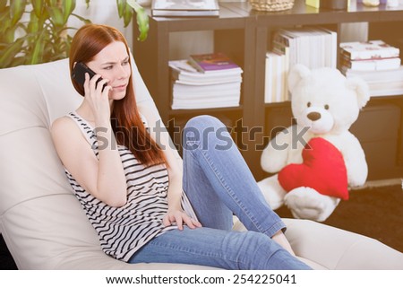 Woman talking to someone on the mobile phone in the room.