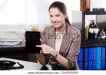 Elegant business woman show the tablet screen in the office.