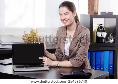 Elegant business woman show the notebook screen in the office.