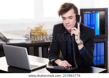 Business man call someone on the landing phone in the office