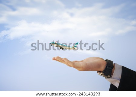 Image of business man with airplane flying out of his hand