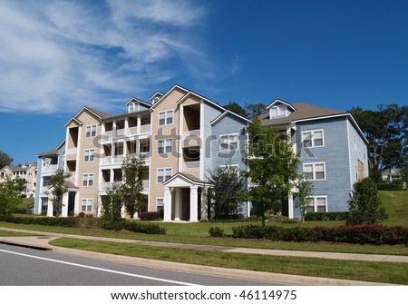 Three story condos, apartments or town homes with vinyl siding of blue and tan.