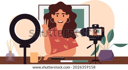 Young female blogger records herself on video using a video camera and a light lamp. Vector character creating a video review for a blog.Vlogger cartoon character records video indoors. Flat design