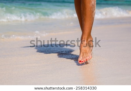 Nice legs of a pretty girl walking in coastline