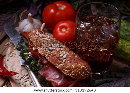 A delicious sandwich with cold cuts, salad and tomato on fresh multi grain bread. Rustic food.