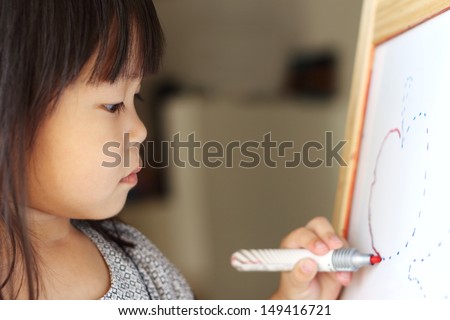 Asian girl tracing a drawing with marker pen on a drawing board