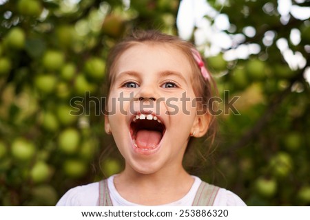 Portrait of a cute little girl making an excited face with her mouth wide open