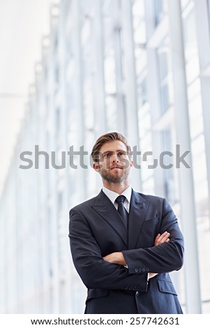 Low angle shot of a corporate executive in a modern architectural setting looking ahead confidently