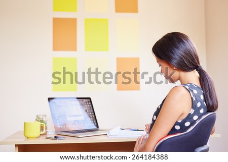 A young woman working on her laptop in her office