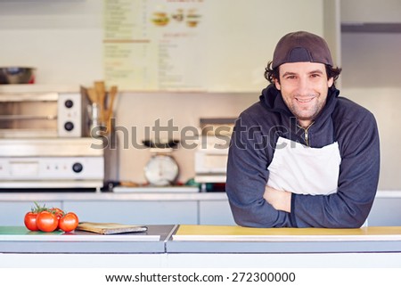 Entrepeneur looking friendly and confident in his clean food stall where he makes takeaway food