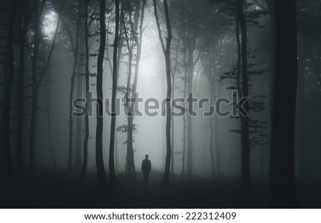 spooky halloween scene with man in dark forest