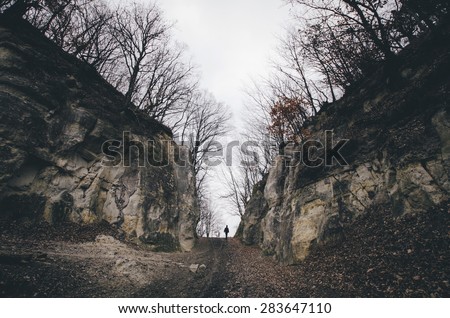 man on path between cliffs