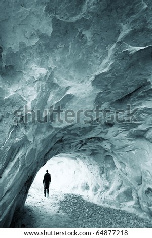 man walking out of a cave