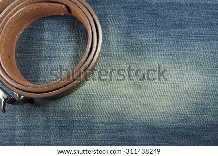 leather belt on blue jeans background