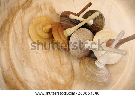 Handmade spinning-top on a a big wooden plate.