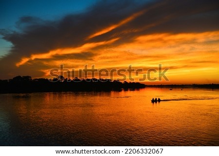 The silhouette of a small motorized canoe on the Guaporé - Itenez river at sunset, Ricardo Franco village, Vale do Guaporé Indigenous Land, Rondonia, Brazil, on the border with Bolivia Stockfoto © 