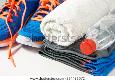 Fitness gym accessories with sport clothing, towel, drinking water and running shoes
