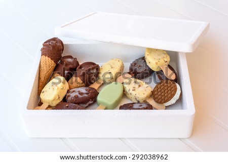 A box full of ice cream of different shapes on a white striped background