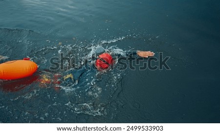 Similar – Image, Stock Photo Female athlete in wetsuit on calm lake shore