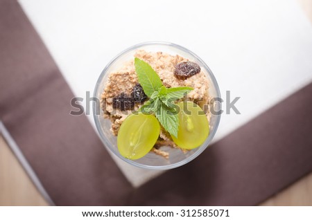 Glass of cereal product with fruit and mint on a top