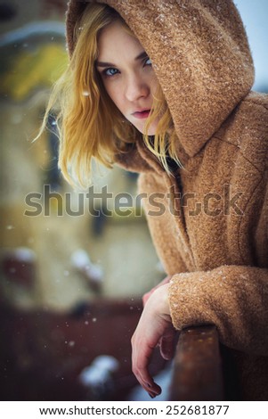 the girl in the coat on the street in winter