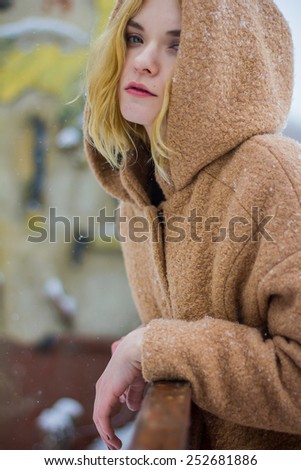 the girl in the coat on the street in winter
