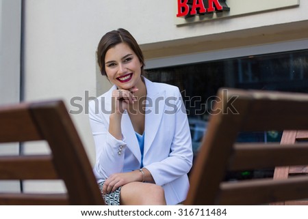 fashionable girl in a blouse sitting on the bench