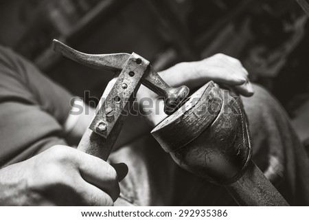 old artisian shoemaker hit shoes with hammer