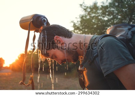 hiker Man dropping fresh water on his head