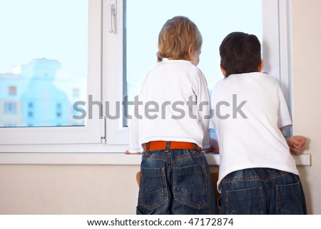 two kids looking at window