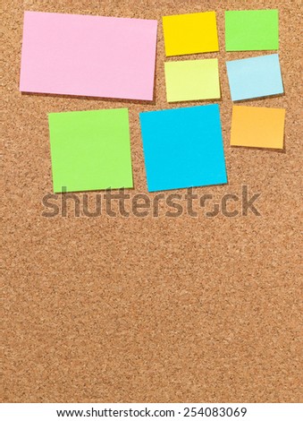 Different blank colored notepads on cork board